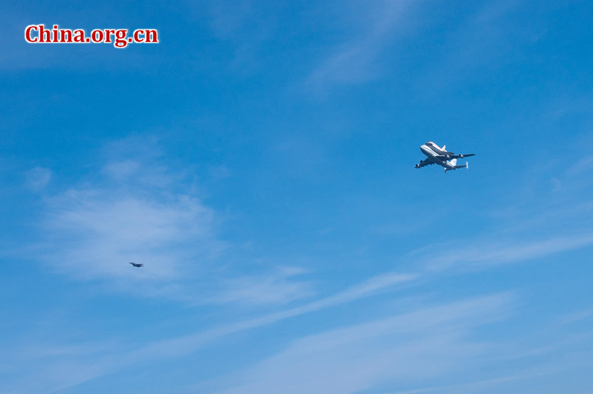 One USAF fighter jet escorts the Endeavour during its five-hour flyover of California's major landmarks. [Chen Boyuan/China.org.cn]