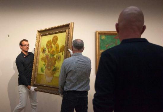 Curators remove Vincent van Gogh's famous 'Sunflowers' painting from the wall of the Van Gogh Museum in Amsterdam, Netherlands, Sunday, Sept. 23, 2012.