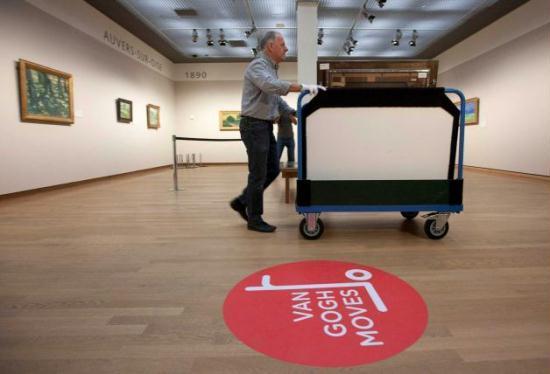 A curator removes Vincent van Gogh paintings on a carrier trolley at the Van Gogh Museum in Amsterdam, Netherlands, Sunday, Sept. 23, 2012.