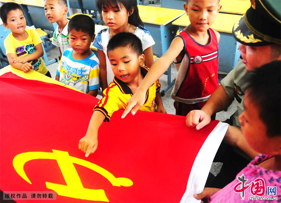 2012年9月1日，小同学们争相回答边防警察叔叔关于党旗的提问。[中国网图片库 周炜摄影]