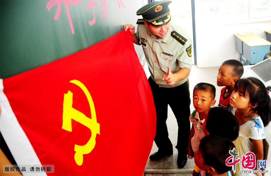 2012年9月1日，浙江台州市桃渚边防派出所民警向小学生讲解党旗的使用场合。[中国网图片库 周炜摄影]