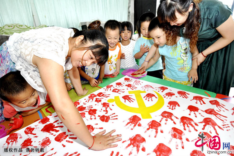 2012年9月1日，在十八大即将召开之际，地处江西省偏远山区的德兴铜矿新区分园90个小孩子在老师的指导下用他们小小手印绘就了一幅鲜艳的中国共产党党旗，欢天喜地迎接“十八大”的到来。[中国网图片库 朱国平摄影]