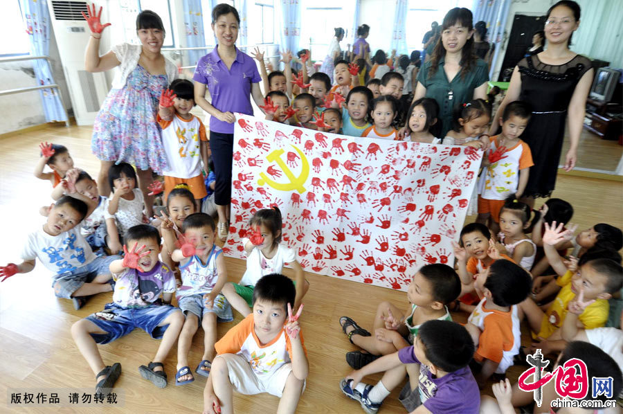 2012年9月1日，在十八大即将召开之际，地处江西省偏远山区的德兴铜矿新区分园90个小孩子在老师的指导下用他们小小手印绘就了一幅鲜艳的中国共产党党旗，欢天喜地迎接“十八大”的到来。[中国网图片库 朱国平摄影]