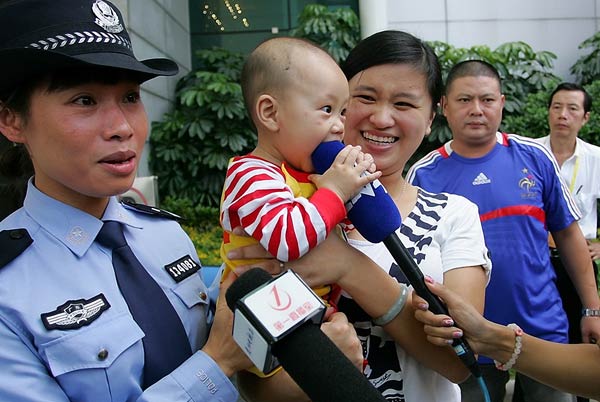 Huang Yuxian, an 8-month-old boy who was trafficked from Guangdong to a small village in Central China's Henan province, was rescued. His mother held him tightly in her arms at the airport in Guangzhou on Sunday. [Photo/Yangcheng Evening News]
