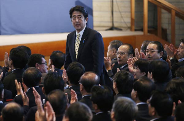 Shinzo Abe of the Liberal Democratic Party, Japan's main opposition group, acknowledges applause from parliamentarians after he was elected LDP leader at their headquarters in Tokyo on Wednesday. [Agencies via China Daily]