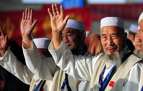 Chinese Muslims making the pilgrimage to Mecca wave to their family members and friends at an airport in Lanzhou, Gansu province, Sept 25, 2012. [Photo/Xinhua]  