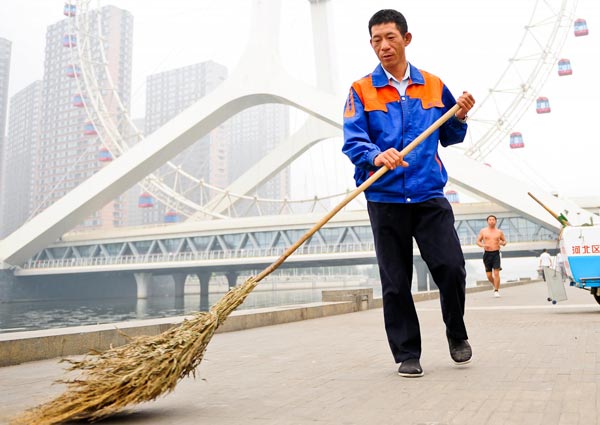 Xu Wenhua sweeps a street in Tianjin, Sept 22, 2012. [Photo/Xinhua] 