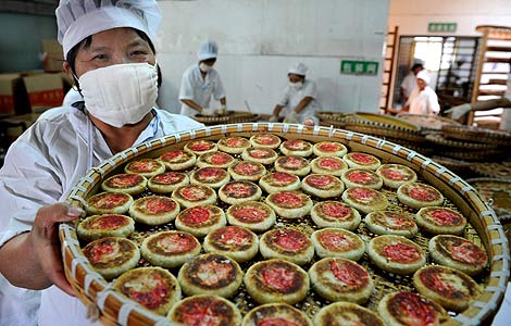 A woman shows self-made mooncakes in Yiwu, Zhejiang province in this Sept 17, 2012 file photo. [Photo/Asianewsphoto]