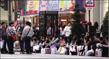 April 11, 2009：A group of Chinese tourists take a break on Tokyo’s Ginza street after an extensive shopping trip. 