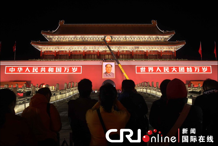 Staff workers hang the newly-drawn portrait of Mao Zedong on the freshly-painted Tiananmen Gate on the evening of Sept. 28. Beijing celebrates the upcoming 63rd anniversary of the founding of the People&apos;s Republic of China.