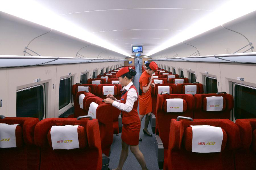 Two attendants aboard G538 prepares for the high-speed train&apos;s first trip to Guangzhou in Zhengzhou, capital of central China&apos;s Henan Province, Sept. 29, 2012. Two high-speed train services were put into use Saturday in Zhengzhou, after the Zhengzhou-Wuhan high-speed railway opened on Friday. The new train services, G538 and G650, will reduce travel time to Guangzhou and Wuhan to six hours and two hours respectively.