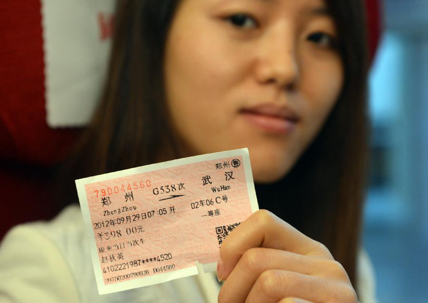 A passenger shows her ticket for high-speed train G538 which travels from central China&apos;s Zhengzhou to Guangzhou in the south, Sept. 29, 2012. Two high-speed train services were put into use Saturday in Zhengzhou, after the Zhengzhou-Wuhan high-speed railway opened on Friday. The new train services, G538 and G650, will reduce travel time to Guangzhou and Wuhan to six hours and two hours respectively. 