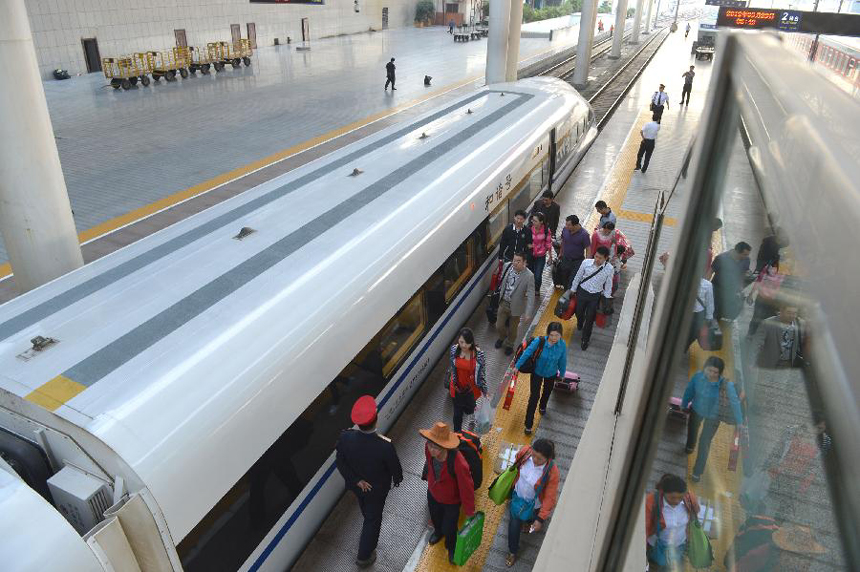 Passengers make their way on the platform to board the high-speed train G538, which travels to Guangzhou, in Zhengzhou, capital of central China&apos;s Henan Province, Sept. 29, 2012. Two high-speed train services were put into use Saturday in Zhengzhou, after the Zhengzhou-Wuhan high-speed railway opened on Friday. The new train services, G538 and G650, will reduce travel time to Guangzhou and Wuhan to six hours and two hours respectively.