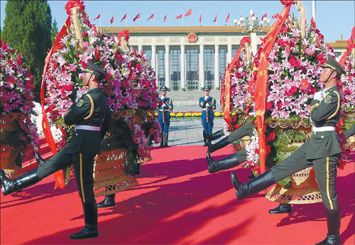Soldiers lay flower baskets at the Monument to the Peoples' Heroes in Tian'anmen Square in Beijing on Monday, China's National Day. [Photo / China Daily]