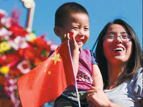 A mother shares a happy moment with her son in front of a giant flower basket in Tian'anmen Square. [Photo / China Daily]