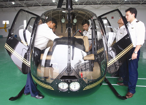 Students learn about the interior of a helicopter at Ruohang. [Photo/China Daily] 