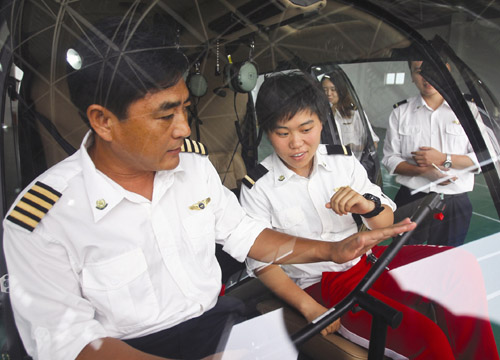 An instructor gives a student a lesson about flying a helicopter. [Photo/China Daily] 