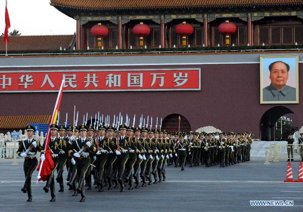 Chinese national flag guards escort the flag across the Chang'an Avenue to the Tian'anmen Square in Beijing, capital of China, Oct. 1, 2012. Tens of thousands of people gathered at the Tian'anmen Square to watch the national flag raising ceremony at dawn on Oct. 1, in celebration of the 63rd anniversary of the founding of the People's Republic of China. [Photo/Xinhua]