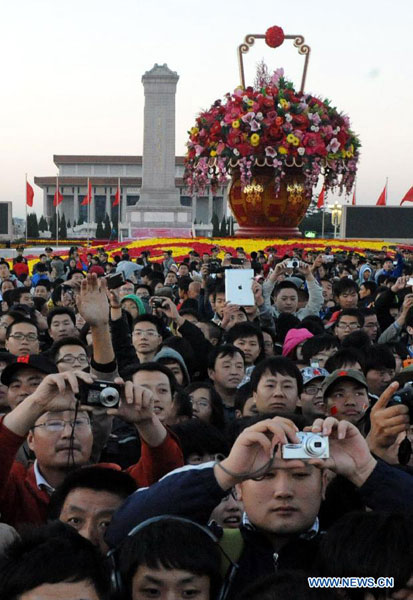 People watch the national flag raising ceremony at the Tian'anmen Square in Beijing, capital of China, Oct. 1, 2012. Tens of thousands of people gathered at the Tian'anmen Square to watch the national flag raising ceremony at dawn on Oct. 1, in celebration of the 63rd anniversary of the founding of the People's Republic of China. [Photo/Xinhua]