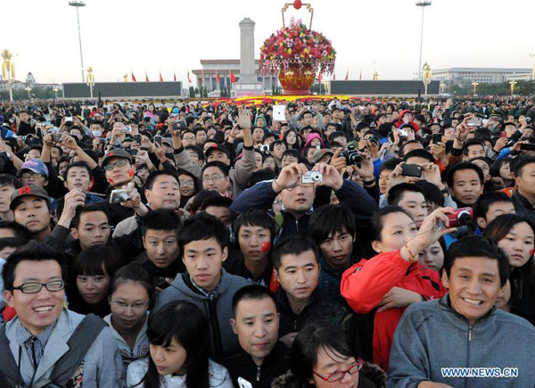 People watch the national flag raising ceremony at the Tian'anmen Square in Beijing, capital of China, Oct. 1, 2012. Tens of thousands of people gathered at the Tian'anmen Square to watch the national flag raising ceremony at dawn on Oct. 1, in celebration of the 63rd anniversary of the founding of the People's Republic of China. [Photo/Xinhua]