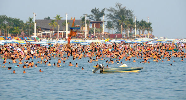 Tourists crowd into the Silver Beach in Beihai city in South China's Guangxi Zhuang autonomous region Oct 1, 2012. The number of travelers in major scenic spots across China had totaled 5.76 million by 5 pm on Oct 2, according to the China National Tourism Administration. [Photo/Xinhua] 