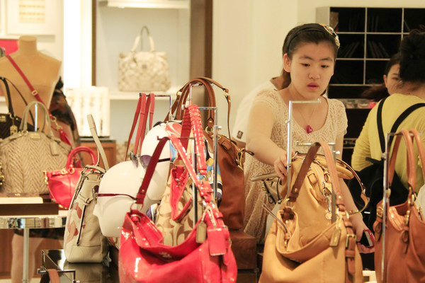 Shoppers select bags at a duty-free store in Sanya, Hainan province. Luxury, but without showing off, is what Chinese consumers look for now. [Huang Yiming / China Daily] 