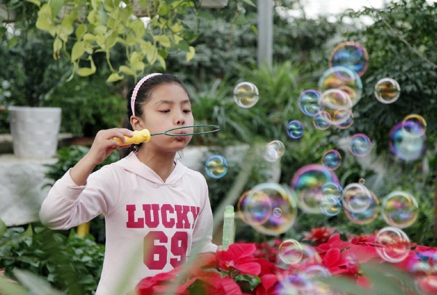 A girl blows bubbles at a flower market in Tengzhou, east China's Shandong Province, Oct. 1, 2012. People around China enjoy themselves in various ways during the Mid-Autumn Festival and Chinese National Day holiday, which lasts from Sept. 30 to Oct. 7.[Photo/Xinhua]