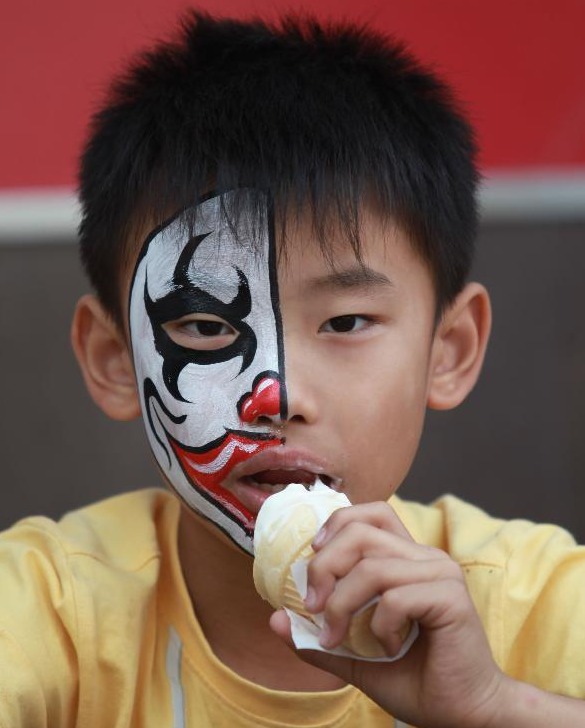 A child eats an ice cream while resting at the Beijing Happy Valley in Beijing, capital of China, Oct. 2, 2012. People around China enjoy themselves in various ways during the Mid-Autumn Festival and Chinese National Day holiday, which lasts from Sept. 30 to Oct. 7.[Photo/Xinhua]