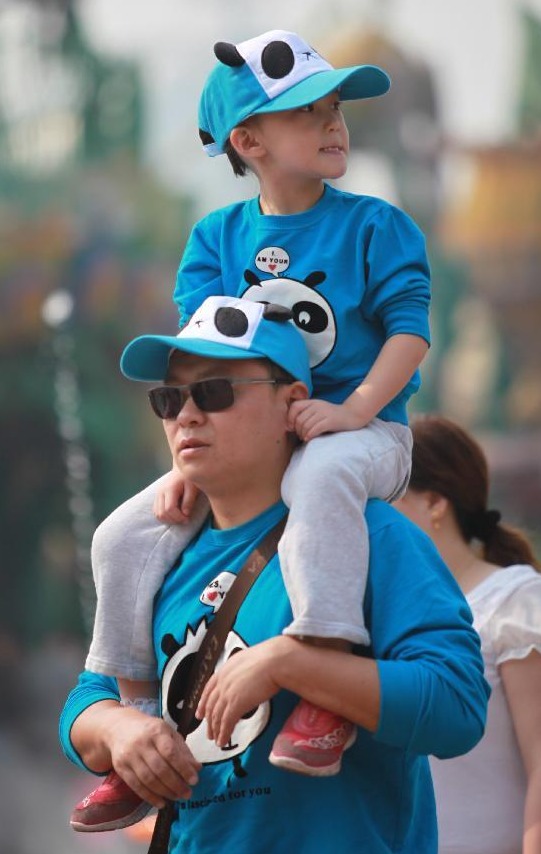 A parent carrying his child walks at the Beijing Happy Valley in Beijing, capital of China, Oct. 2, 2012. People around China enjoy themselves in various ways during the Mid-Autumn Festival and Chinese National Day holiday, which lasts from Sept. 30 to Oct. 7.[Photo/Xinhua]