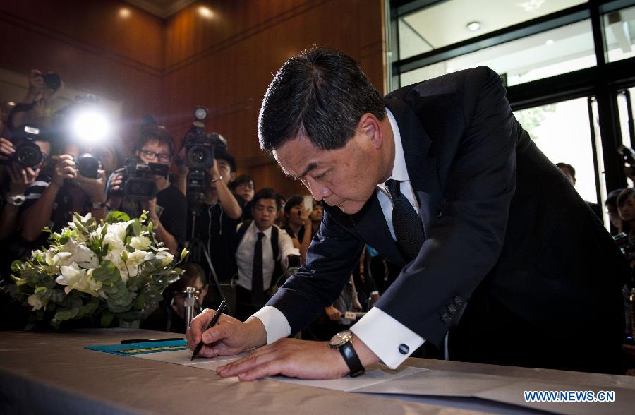 Hong Kong Chief Executive CY Leung signs at a condolence place in Wanchai of Hong Kong on Oct. 4, 2012. Eighteen condolence places were set up in Hong Kong Thursday to mourn for the victims of the ferry accident during which thirty-eight people including at least five children were killed.