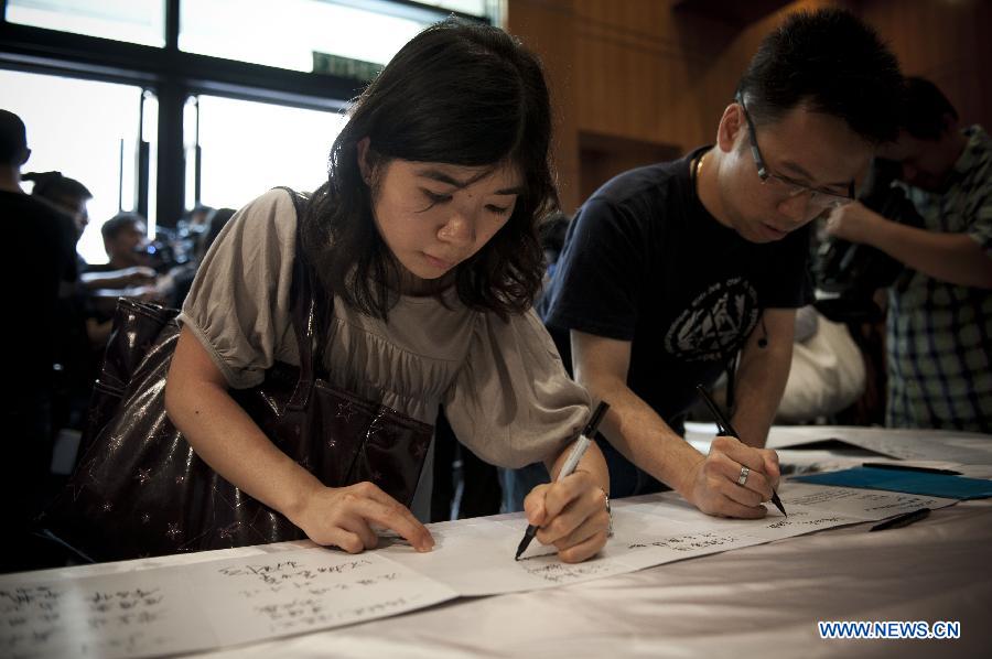 Hong Kong citizens sign at a condolence place in Wanchai of Hong Kong on Oct. 4, 2012. Eighteen condolence places were set up in Hong Kong Thursday to mourn for the victims of the ferry accident during which thirty-eight people including at least five children were killed.