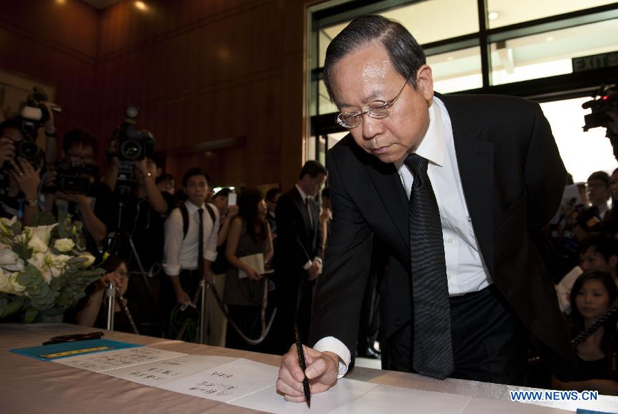 Hong Kong Secretary for Security Lai Tung-kwok signs at a condolence place in Wanchai of Hong Kong on Oct. 4, 2012. Eighteen condolence places were set up in Hong Kong Thursday to mourn for the victims of the ferry accident during which thirty-eight people including at least five children were killed. 