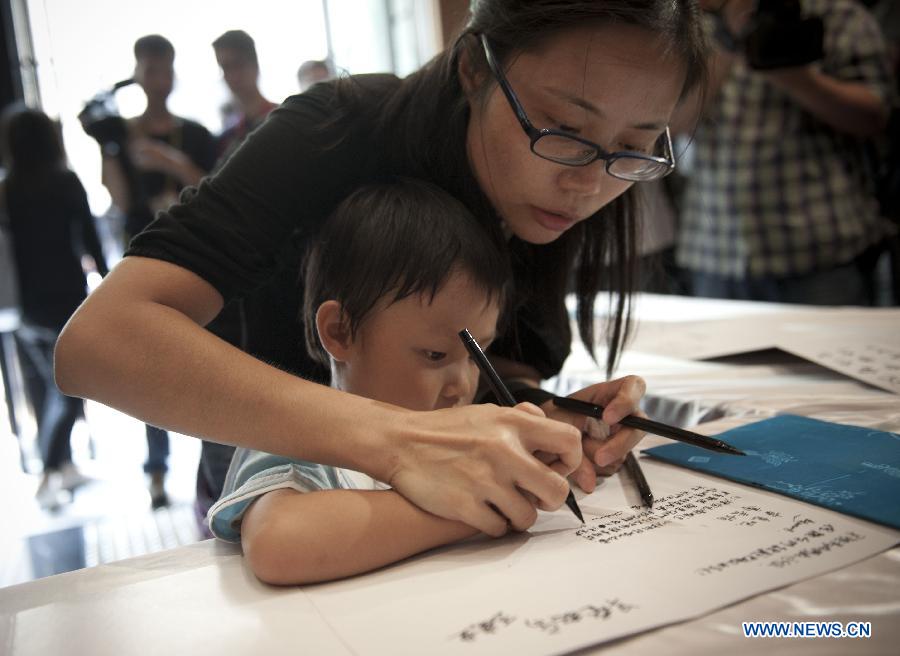 Hong Kong citizens sign at a condolence place in Wanchai of Hong Kong on Oct. 4, 2012. Eighteen condolence places were set up in Hong Kong Thursday to mourn for the victims of the ferry accident during which thirty-eight people including at least five children were killed.