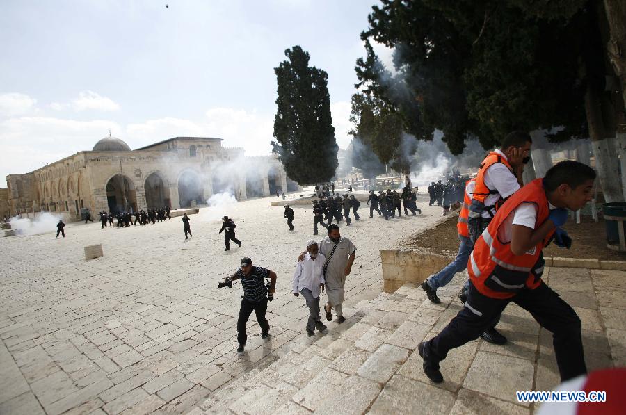 Stone-throwing Palestinian protesters take shelter as they clash with Israeli security officers outside Al Aqsa Mosque in the compound known to Muslims as Noble Sanctuary and to Jews as Temple Mount in Jerusalem's Old City, Oct. 5, 2012. 