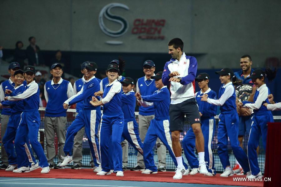 Novak Djokovic (Front) of Serbia dances with the ballkids during the victory ceremony for the men's singles final against Jo-Wilfried Tsonga of France at the 2012 China Open tennis tournament held in Beijing, capital of China, on Oct. 7, 2012. Djokovic won the match 2-0 and claimed the title.