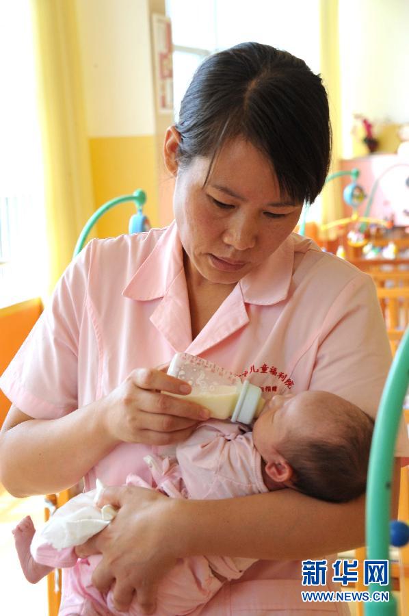 在潍坊儿童福利院，杨守伟像妈妈一样照顾着孤残儿童（9月26日摄）。[新华社]