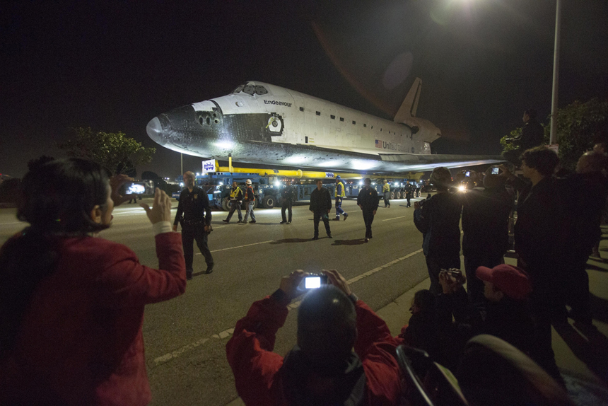 People take pictures as the Space Shuttle Endeavour leaves Los Angeles International Airport in Los Angeles, California, in the early morning hours October 12, 2012 . Endeavour on Friday and begins a two-day ground journey to its final resting place at the California Science Center. NASA Space Shuttle Program ended in 2011 after 30 years and 135 missions. [Xinhua photo]