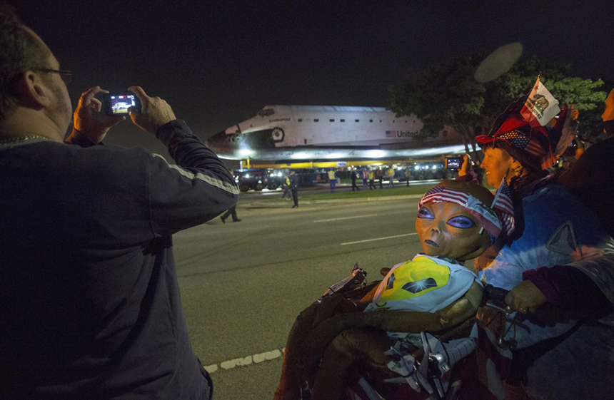 People take pictures as the Space Shuttle Endeavour leaves Los Angeles International Airport in Los Angeles, California, in the early morning hours October 12, 2012 . Endeavour on Friday and begins a two-day ground journey to its final resting place at the California Science Center. NASA Space Shuttle Program ended in 2011 after 30 years and 135 missions. [Xinhua photo]