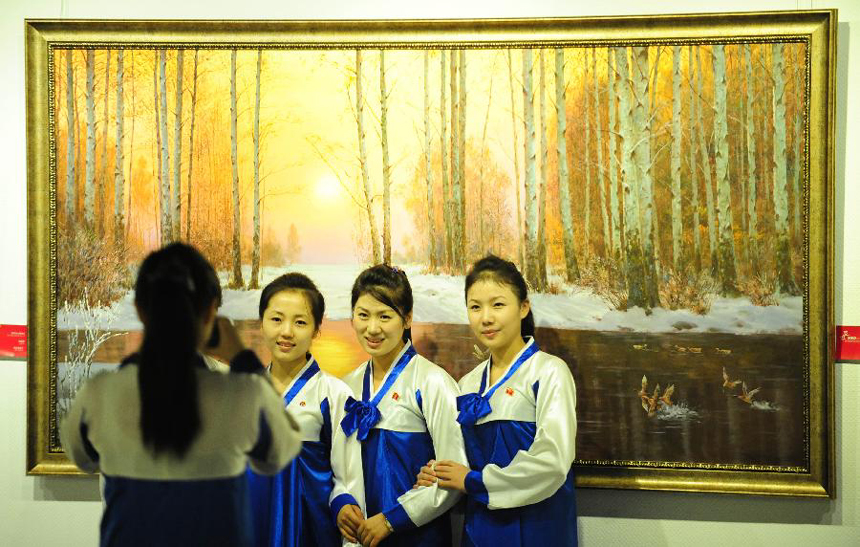 Girls from the Democratic People&apos;s Republic of Korea (DPRK) pose for photos at the DPRK Art Exhibition in Dandong, northeast China&apos;s Liaoning Province, Oct. 12, 2012. The exhibition was held as part of the activities during the China-DPRK Economic, Trade, Cultural and Tourism Expo from Oct. 12 to 16 in Dandong, which borders the DPRK.