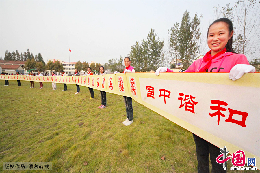 10月9日，江苏省赣榆县罗阳镇中心小学的学生们在校园的操场上展示长达38.8米的《和谐中国》刻纸长卷。