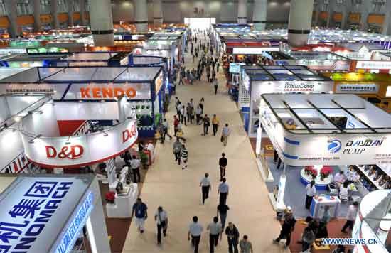 People walk past exhibition halls of the 112th China Import and Export Fair in Guangzhou, capital of south China's Guangdong Province, Oct. 15, 2012. 