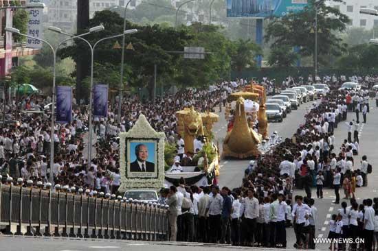 A convoy transporting the coffin of the late former king Norodom Sihanouk drives past mourning people on its way from the Phnom Penh International Airport to the Royal Palace in Phnom Penh, capital of Cambodia, on Oct. 17, 2012. [Xinhua] 