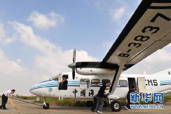 中国海监东海航空支队舟山基地工作人员正在进行B－3837飞机备航（10月17日摄）。[新华社 张建松 摄]