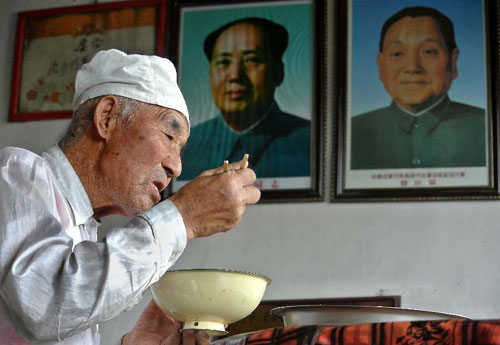 Guo Tongwang, a 91-year-old forest keeper, has lunch in his office in Maotuan Village of Dongkeng Township, Jingbian County, northwest China's Shaanxi Province, Aug. 23, 2012.[Photo/Xinhua]