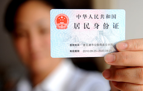 A woman shows her ID in Lianyungang, East China's Jiangsu province in this Oct 29, 2011 file photo. [Photo by Geng Yuhe/Asianewsphoto] 