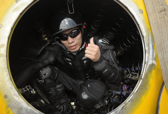 Yang Zongfu, 32, from Yiwu, Zhejiang province climbs into the 'Atlantis', a gigantic ark that is built to withstand December's Mayan doomsday, on Aug 6, 2012. [Photo/CFP] 