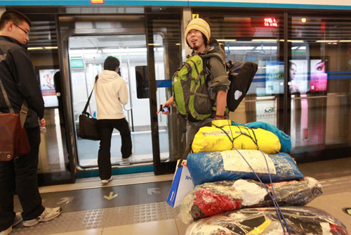 Japanese cyclist Kawahara Keiichiro enters a subway station with his relief resources in Beijing, before his flight to a quake-hit area in southwest China's Yunnan Province on Wednesday, October 24, 2012. [Photo/CFP] 