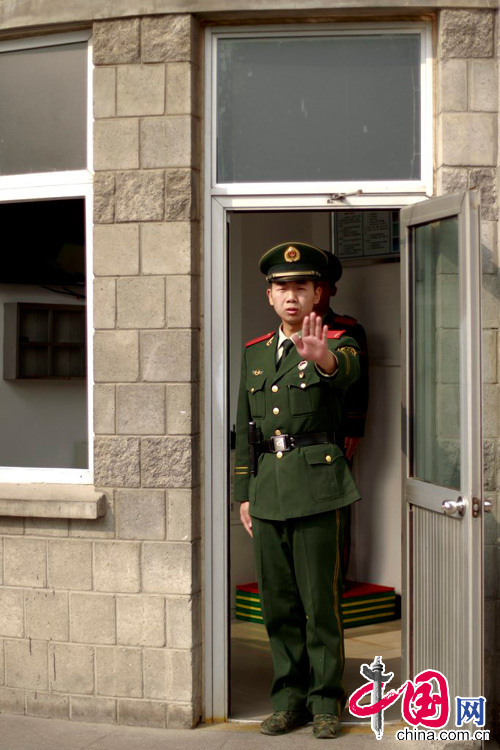 2012年10月25日，北京，警卫对摄影师作出手势。北京公安监管场所举行境外媒体开放日。来自美国、英国、德国、法国等20余个国家的40余名媒体记者应邀参观了北京市第一、第二看守所。[CFP]