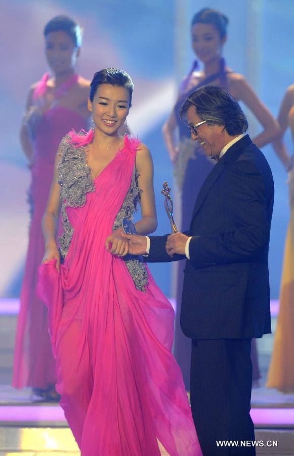 Contestant Xu Jing (L) claims the award of popularity on the network during the finale of 2012 Miss Chinese Cosmos Pageant in south China's Hong Kong, Oct. 27, 2012. Xu also won the second place of the contest.