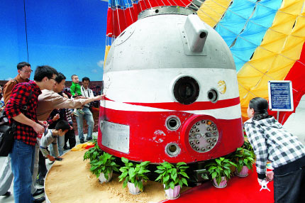 Visitors take a close look at the re-entry capsule of the Shenzhou-4 spaceship.
